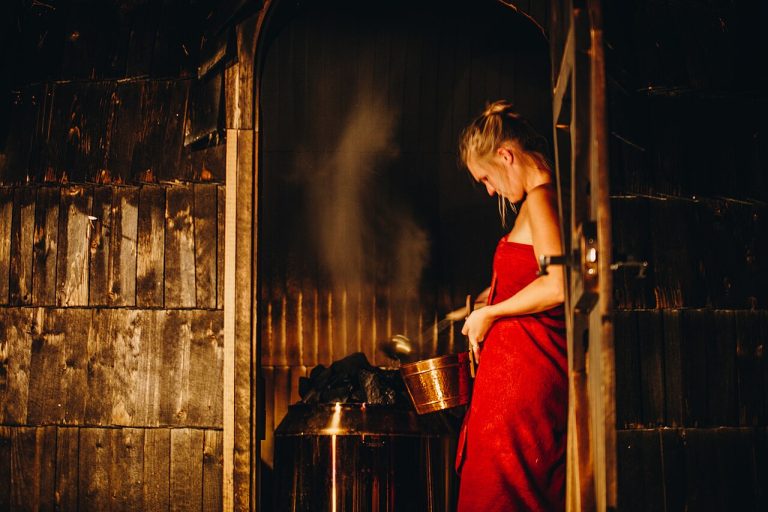 Water poured onto hot stones releases steam in a smoke sauna.