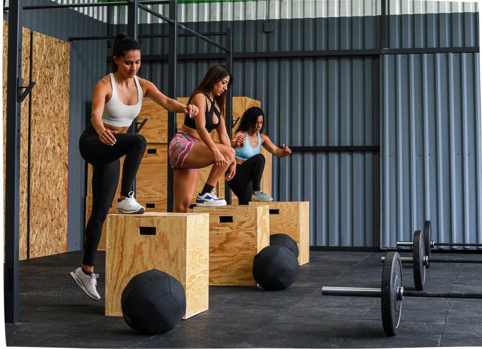 Athletes performing box jumps in a gym